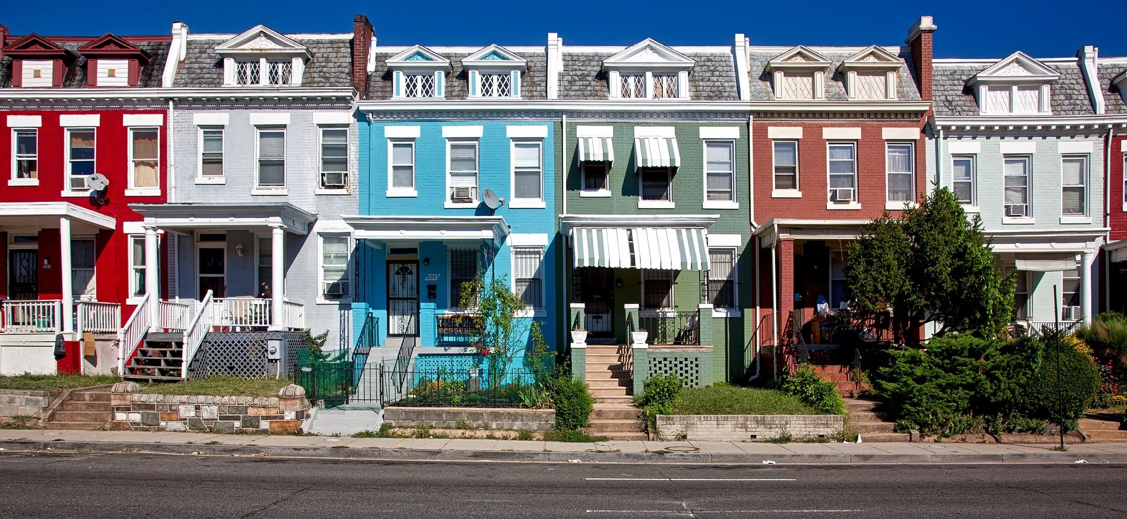 Colourful row houses on a residential street — the kind of income-generating property held inside a residential REIT